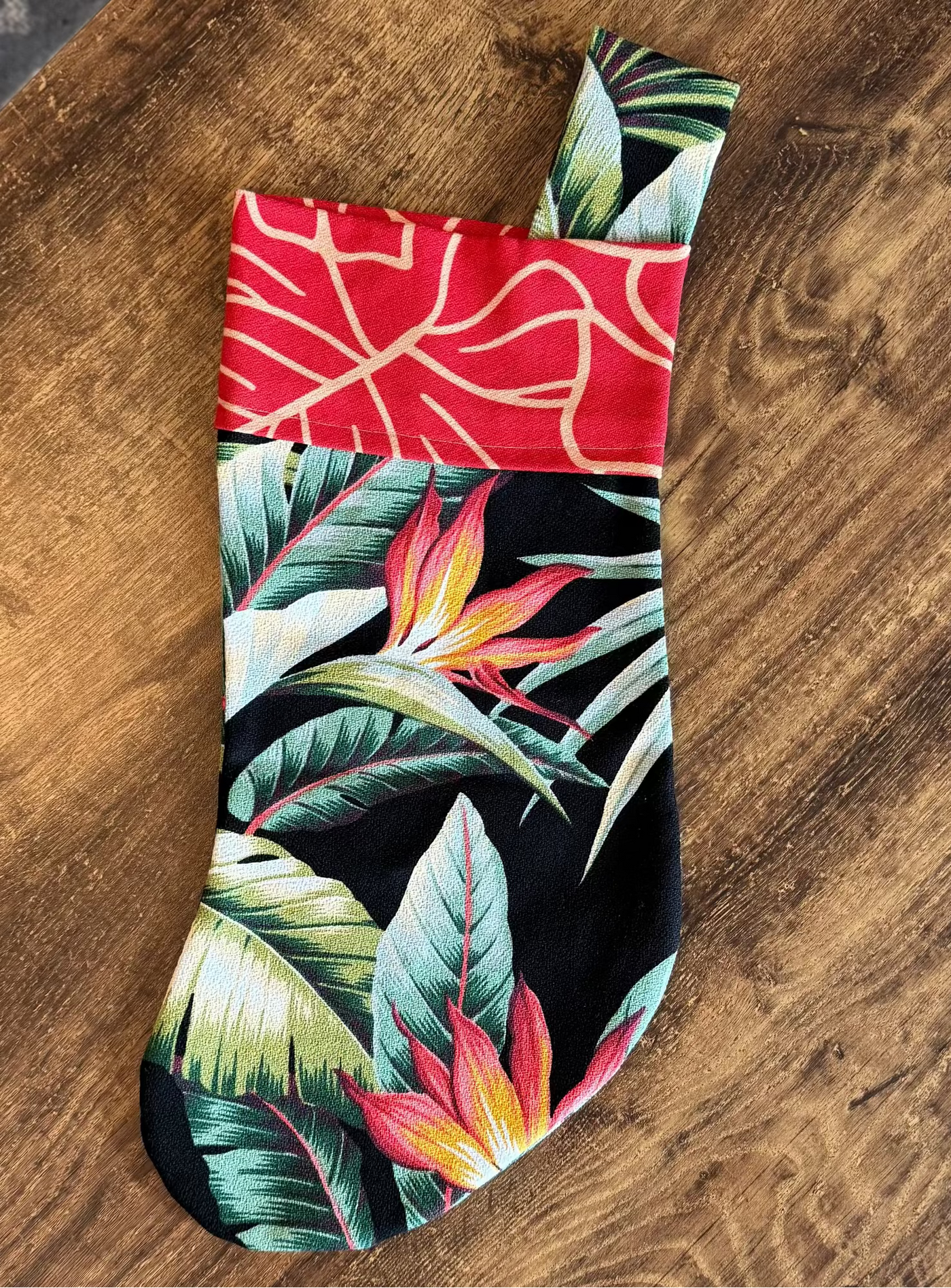 Tropical leaf patterned sock on a wooden surface